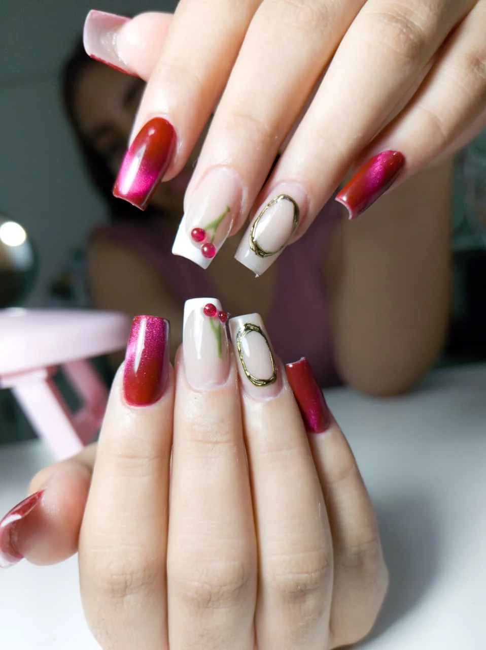 Nail art cereja em tons vinho, branco e dourado em Balneário Camboriú