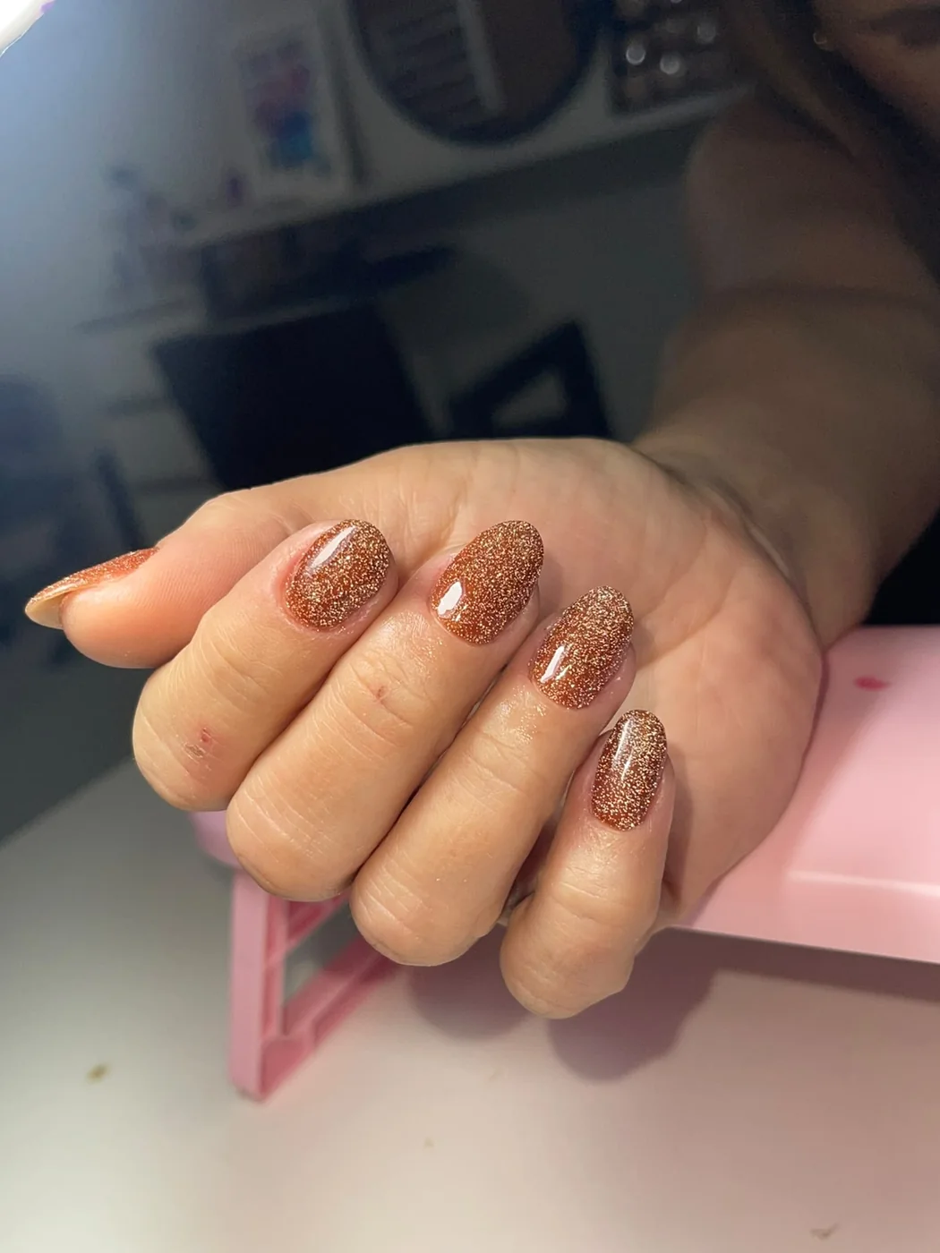 Unhas em gel bronze com glitter e acabamento luminoso em Balneário Camboriú